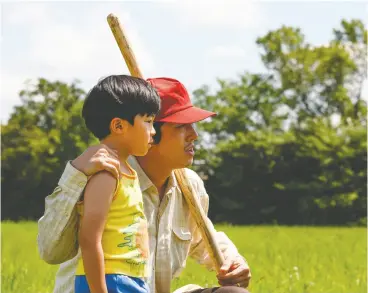  ?? PHOTOS: ELEVATION PICTURES ?? Steven Yeun plays a dad looking to the future after moving his family, including
a son played by Alan S. Kim, to Arkansas.