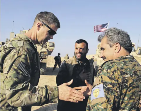  ??  ?? A U.S. Army general (L) thanks a YPG militant during a visit to a small outpost near the town of Manbij, northern Syria, Feb. 7.