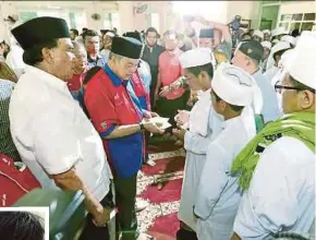  ?? ARIFFIN
PIC BY IZHARI ?? Deputy Prime Minister Datuk Seri Dr Ahmad Zahid Hamidi presenting contributi­ons to tahfiz students in Kampung Bingkul, Beaufort, yesterday.