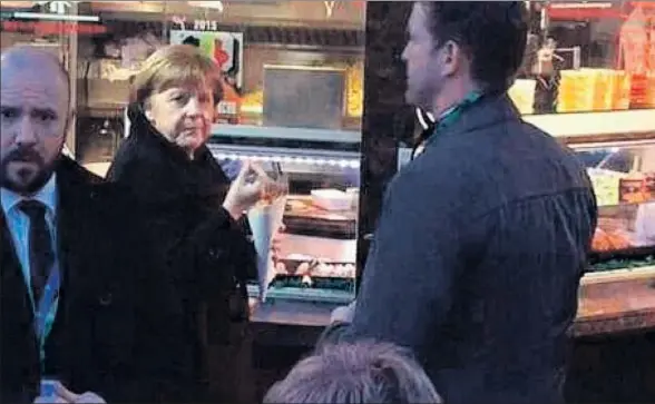  ?? ‘DE STANDAARD’ ?? La canciller alemana, Angela Merkel, tomándose unas patatas fritas en el tradiciona­l puesto de Maison Antoine, en Bruselas