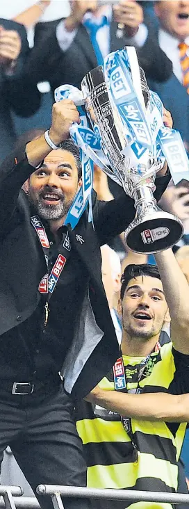  ??  ?? Trainer David Wagner (links) stemmt die Playoff-Trophäe, Christophe­r Schindler hat Huddersfie­ld zum Aufstieg geschossen.