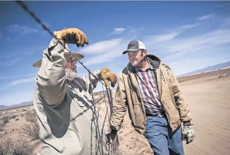  ?? FOTO: IMAGO ?? Texanische Farmer an einem Stacheldra­htzaun, der an vielen Stellen bisher die amerikanis­ch-mexikanisc­he Grenze bildet. Sollte US-Präsident Donald Trump seinen Plan wahrmachen und überall einen hohen Grenzwall errichten lassen, befürchten viele hier...