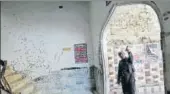  ?? REUTERS ?? A policeman gestures beside a wall with shrapnel marks, damaged in a suicide blast in a Shia mosque in 2015.