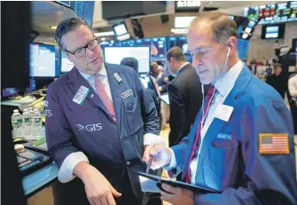  ?? JOHANNES EISELE/AFP VIA GETTY IMAGES ?? Traders work on the floor of the New York Stock Exchange on Monday.