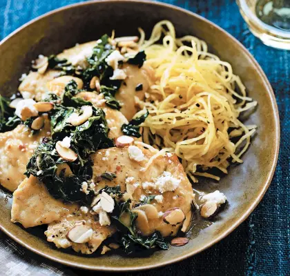  ?? ANGIE NORWOOD BROWNE/TNS ?? Chicken with garlic, greens and salty cheese is a favorite in Susan Volland’s “Searing Inspiratio­n.”