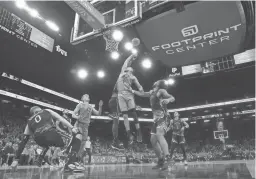  ?? JOE RONDONE/THE REPUBLIC ?? Suns guard Devin Booker battles for a rebound with Warriors forward JaMychal Green during Wednesday night’s game at Footprint Center in Phoenix.