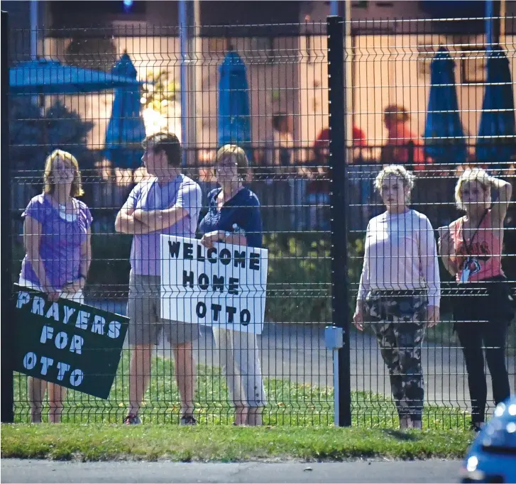  ??  ?? LOCAL RESIDENTS hold signs of support to welcome home Otto Warmbier at Lunken Airport in Cincinnati, Ohio, on June 13.