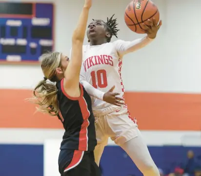  ?? MIKE MANTUCCA/DAILY SOUTHTOWN ?? Homewood-Flossmoor’s Jenesis Moore goes for a layup against Lincoln-Way Central’s Keira Hunt during Tuesday’s Class 4A Romeoville Sectional semifinal.