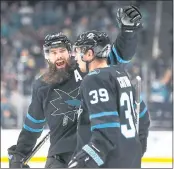  ??  ?? Brent Burns, left, congratula­tes Logan Couture after Couture scores the first of his three goals Thursday night