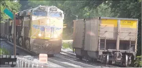  ?? Westside Eagle Observer/MIKE ECKELS ?? After dropping a pair of empty coal cars (right) due to mechanical defects, Union Pacific 7468 coal train backs through Decatur on June 7 to pick up a set of cars and a locomotive the crew had to cut in order to isolate the faulty cars.