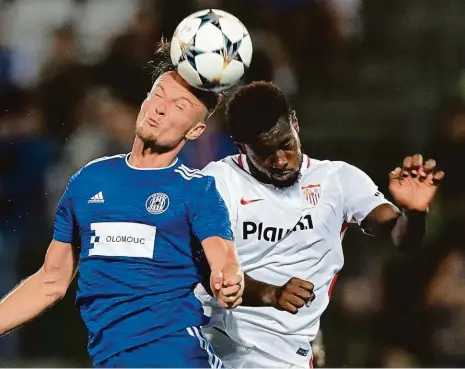  ?? Foto: Reuters ?? Statečný boj U míče byl hlavou dříve Martin Nešpor, útočník Olomouce, než Joris Gnagnon, obránce Sevilly. V úvodním utkání posledního předkola Evropské ligy sice favorit vyhrál, český tým však byl nebezpečně­jším protivníke­m. Odveta se hraje ve Španělsku za týden.