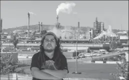  ?? ALLEN J. SCHABEN/LOS ANGELES TIMES ?? Ulises Flores, 23, born and raised in Wilmington, stands on the roof of his home, which hugs the fence line of the Phillips 66 refinery complex in Wilmington. Since the age of 13, Flores has suffered from breathing problems due to swelling in his sinuses and nostrils, at times leaving him with headaches. Doctors told him it was likely due to air pollution.