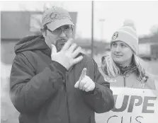  ??  ?? Canadian Hearing Society client Chris Newman uses sign language to express his concerns along with staff interprete­r Courtney Cockburn during a CUPE rally on Friday.