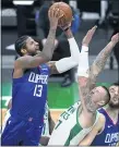  ?? ELISE AMENDOLA — THE ASSOCIATED PRESS ?? The Clippers’ Paul George, left, who scored 32 points, puts up a shot as center Daniel Theis of the Boston Celtics defends Tuesday night.