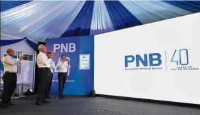  ?? — Bernama ?? New chapter: Najib admiring the new PNB logo during the company’s 40th anniversar­y celebratio­n in Kuala Lumpur. Looking on are (from left) PNB chief executive officer Datuk Abdul Rahman Ahmad, Johari and Abdul Wahid.