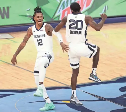  ?? JOE RONDONE/THE COMMERCIAL APPEAL ?? Grizzlies guards Ja Morant and Shaq Buchanan celebrate a lob connection assisted by Morant during their game against the Atlanta Hawks at the Fedexforum on Thursday.