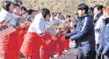  ??  ?? Las jugadoras del equipo femenino de Corea del Norte (a la izquierda) saludan ayer a sus pares del Sur, en el centro de entrenamie­nto de Jincheon.