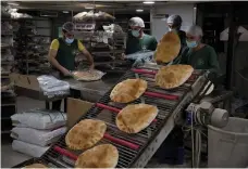  ?? AP ?? Fresh flatbread is packaged at an automated bakery in the southern Beirut suburb of Dahiyeh