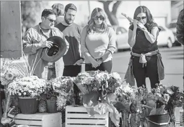  ?? Gina Ferazzi Los Angeles Times ?? ROSIE RITCHIE, right, holds a cross while standing with other family members at a memorial near where Joseph Awaida, his toddler son, Omar, and his wife, Raihan Dakhil, were struck by a suspected DUI motorist.