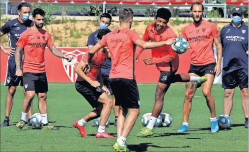  ??  ?? Koundé, en el centro del rondo, intenta intercepta­r la pelota en una acción del entrenamie­nto de ayer del Sevilla.