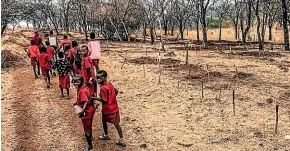  ?? HALO TRUST ?? Big kids watch out for little ones on their way to school along informal paths through minefields in the southern African country of Zimbabwe.