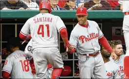  ?? GREG FIUME / GETTY IMAGES ?? Carlos Santana of the Philadelph­ia Phillies celebrates with manager Gabe Kapler after scoring against the Washington Nationals in a recent game.