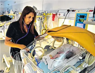  ?? ?? 2. Control. Ana María Rognone revisa a un bebe dentro de la incubadora.