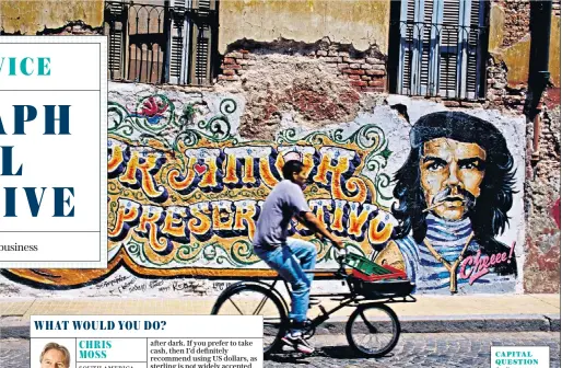  ??  ?? CAPITAL QUESTIONCy­cling past a Che Guevara mural in Buenos Aires, Argentina