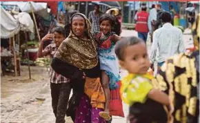  ?? EPA PIC ?? Rohingya refugees walking through the rain at the Balukhali refugee camp near Cox’s Bazar in Bangladesh. More than half of Myanmar’s one million Rohingya have fled the country since violence reignited in August.