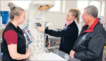  ??  ?? LIFE-SAVING COMFORT: Student midwives Clare Henstridge, left, and Emily Langley show Blue Ribbon Foundation Horsham branch president Dale Russell how Wimmera Health Care Group’s new neonatal resuscitat­ion cot works.