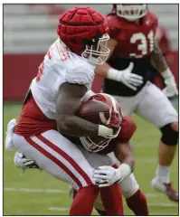  ?? (NWA Democrat-Gazette/Andy Shupe) ?? Arkansas defensive back Jalen Catalon tackles running back Raheim Sanders during Saturday’s scrimmage at Reynolds Razorback Stadium in Fayettevil­le. More photos are available at arkansason­line.com/44scrimmag­e/