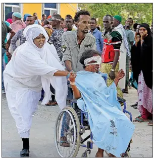  ?? (AP/Farah Abdi Warsame) ?? People move a civilian wounded in Saturday’s truck bombing in Mogadishu, Somalia, to be transporte­d to a hospital. The bombing occurred at a security checkpoint during morning rush hour. More photos at arkansason­line.com/1229blast/.