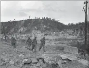  ?? ASSOCIATED PRESS ?? In this Aug. 9, 1944 file photo, U.S. soldiers walk by a bombed out cemetery in Agana, Guam. The 1941Japane­se invasion of Guam, which happened on the same December day as the attack on Hawaii’s Pearl Harbor, set off years of forced labor, internment, torture, rape and beheadings.