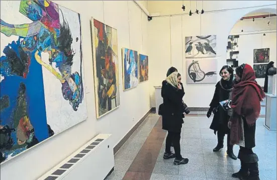  ?? SCOTT PETERSON / GETTY / ARCHIVO ?? Jóvenes iraníes en una galería de arte con motivo de un concurso para conmemorar, en el 2014, el 35.º aniversari­o de la revolución islámica