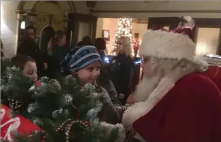  ?? ZACHARY SRNIS — THE MORNING JOURNAL ?? Kenzie Warden, 6, of Sheffield Lake, tells Santa what she wants for Christmas Saturday at Waterfront Winterfest in downtown Lorain.