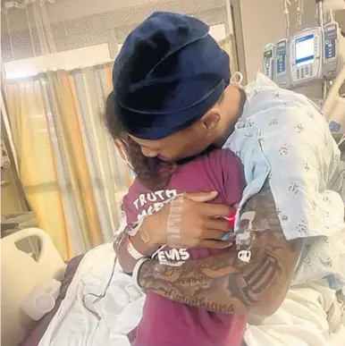  ?? COURTESY ?? Denzel Irvin is hugged by his daughter Maya Faith Irvin as he awaits a heart transplant in a Charlotte, N.C., hospital.