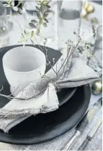  ??  ?? Black ceramic crockery and recycled glasses have a textural appeal, as do the rough-edged linen napkins tied with twine.