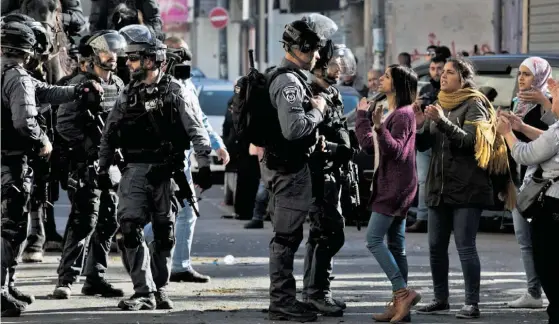  ??  ?? Mulheres palestinia­nas desafiam polícias israelitas em Jerusalém Oriental, que tem sido palco de confrontos nos últimos dias