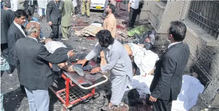  ?? AP ?? People help victims of a bomb blast claimed by Jamaat-ul-Ahrar, in Quetta, Pakistan, on Aug 8.