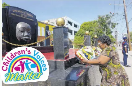  ?? ?? Michelle Mcintosh Harvey, acting CEO of the Child Protection and Family Services Agency, lays a wreath at the Secret Gardens monument in downtown Kingston, on May 7, during the annual Kingston and St Andrew Municipal Corporatio­n wreath-laying ceremony in memory of children who have died under violent and tragic circumstan­ces.