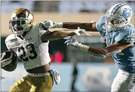  ?? ROBERT WILLETT / THE NEWS & OBSERVER VIA AP, POOL ?? Notre Dame’s Kyren Williams (23) rushes past North Carolina’s Jeremiah Gemmell (44) during the fourth quarter of Friday’s game in Chapel Hill, N.C.