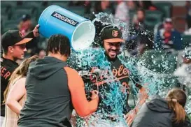  ?? JOHN BAZEMORE/AP ?? The Orioles’ Anthony Santander is doused by teammate Adam Frazier after beating the Braves Friday in Atlanta. The series against the Braves offered an early taste of what the rest of the season could look like for the Orioles, whose remaining schedule is among the toughest in the major leagues.