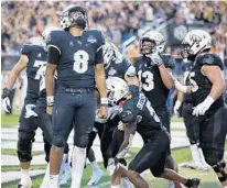  ?? STEPHEN M. DOWELL/ORLANDO SENTINEL ?? UCF quarterbac­k Darriel Mack Jr. (8) screams in celebratio­n after leading the Knights to a touchdown against Memphis on Saturday.