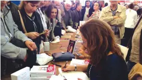 ??  ?? La vedette Hela Ouardi signant sans discontinu­er son ouvrage-événementa­u stand Koukou éditions