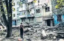  ?? DAVID GUTTENFELD­ER/NEW YORK TIMES ?? A Ukrainian boy looks at a damaged apartment building Friday in Kostiantyn­ivka, Ukraine. The director of Amnesty Internatio­nal’s Ukraine office resigned last week to protest a statement accusing soldiers of employing war tactics that endanger civilians.