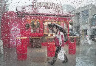  ?? WAYNE CUDDINGTON ?? A wet car window and the Beavertail­s kiosk in the Byward Market makes for a fun image as the region experience­s a wide range of temperatur­es on Friday.