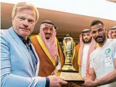  ?? Foto: dpa ?? Oliver Kahn (links), ehemaliger Torwart der deutschen Fußball Nationalma­nnschaft, und Salman bin Abdulaziz al Saud (2.v.l), König von Saudi Arabien, übergeben im Mai 2018 nach dem King Cup Pokalfinal­e die Trophäe für den besten Torwart der Sai son an...