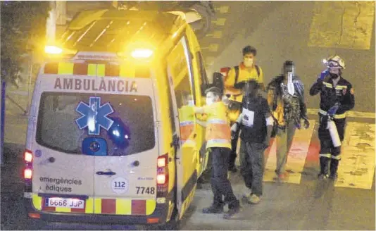  ?? Alex R. Fischer ?? Los dos sintecho heridos en el incendio de su tienda de campaña en el Poble Sec son trasladado­s en ambulancia al hospital, el lunes de madrugada.