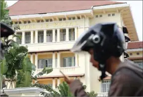  ?? ADDITIONAL REPORTING HONG MENEA ?? A motorist passes in front of Phnom Penh’s Hotel Le Royal in Phnom Penh.