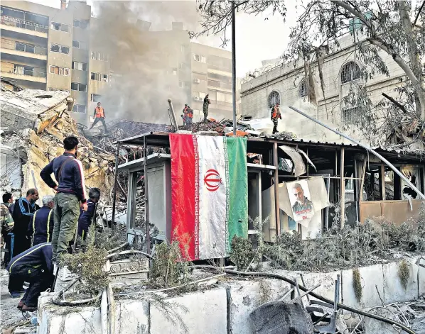  ?? ?? An Iranian flag hangs in the ruins of a building near the Iranian embassy in Damascus after what Iranian media said was an Israeli air strike. Syrian state television said that everyone in the building was killed or wounded